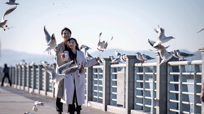 People enjoy life by bank of Dianchi Lake in Kunming, SW China